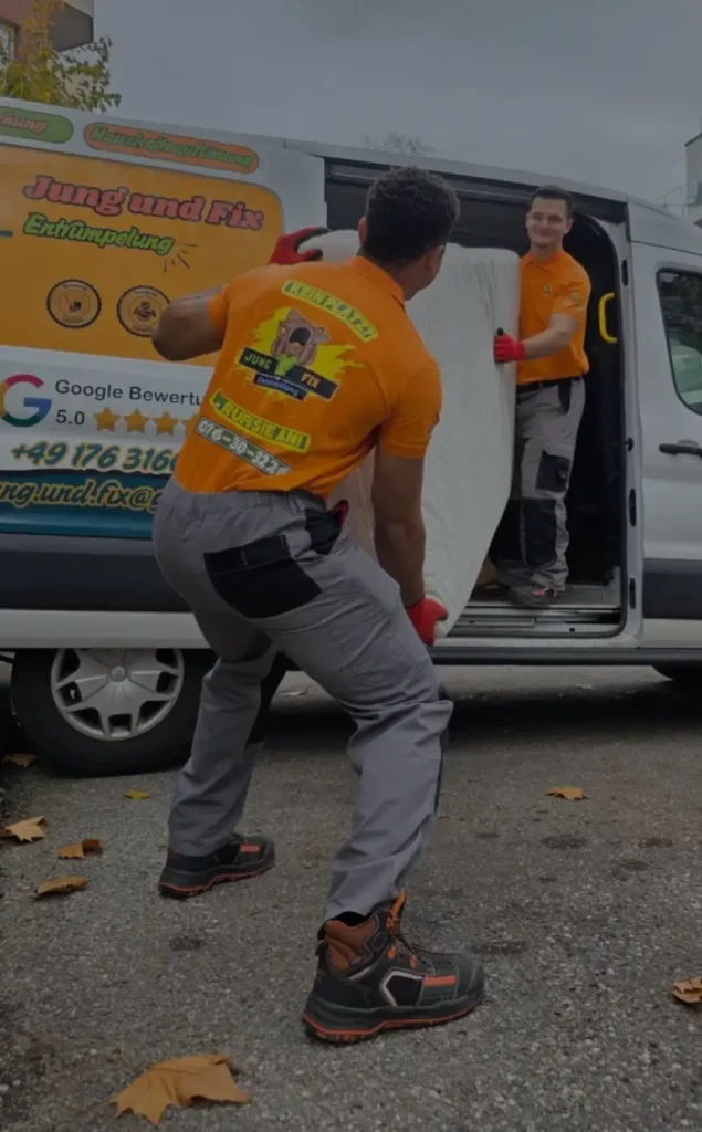 Zwei Entrümpler von Jung und Fix in orangenen T-Shirts mit Firmenlogo führen eine professionelle Entrümpelung und Haushaltsauflösung in Aachen durch. Sie verladen eine Matratze in den folierten Firmenwagen von Jung und Fix zur fachgerechten Entsorgung.